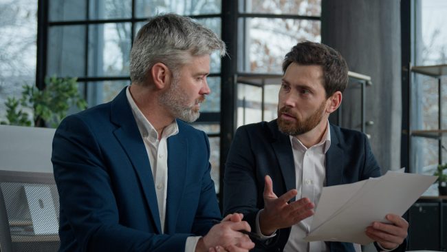 Two disgruntled furious Caucasian businessmen arguing about bad contract in office men colleagues partners dispute incorrect document failed transaction deal conflict problem shouting break agreement